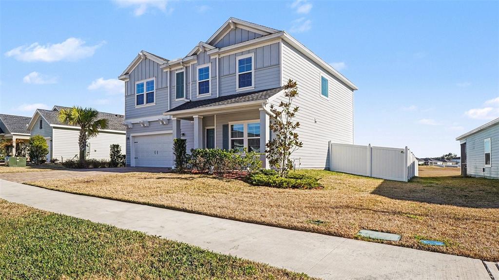 A two-story light gray house with a two-car garage and a white vinyl fence — 1795 NW 44TH COURT ROAD, OCALA, FL