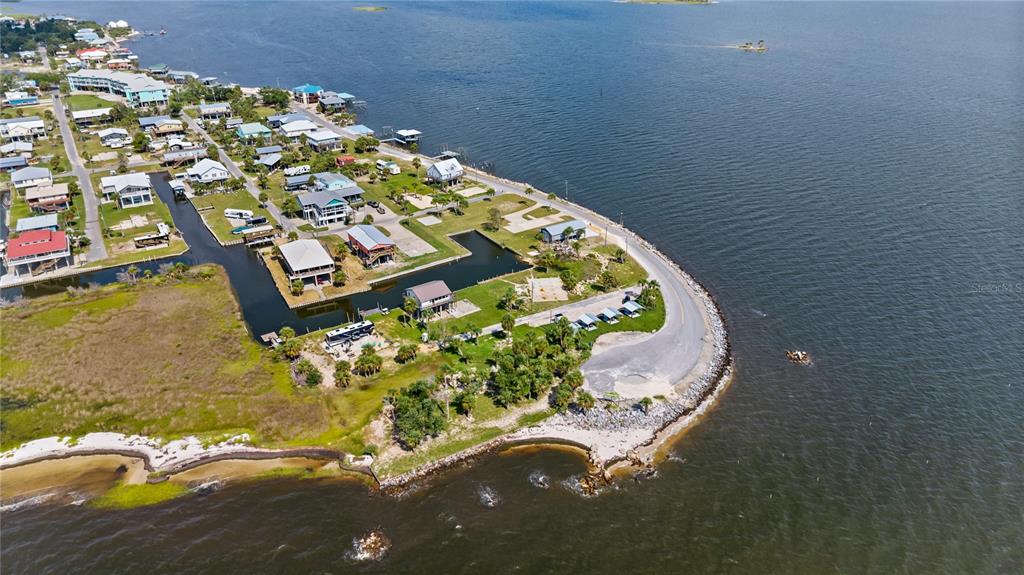 An aerial view shows coastal homes along a road bordering a bay and marshland — 758 MAIN STREET, HORSESHOE BEACH, FL