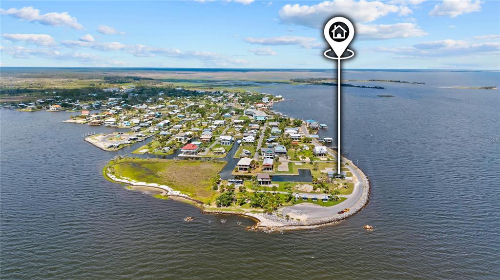 An aerial view shows a coastal community on a peninsula surrounded by water — 758 MAIN STREET, HORSESHOE BEACH, FL