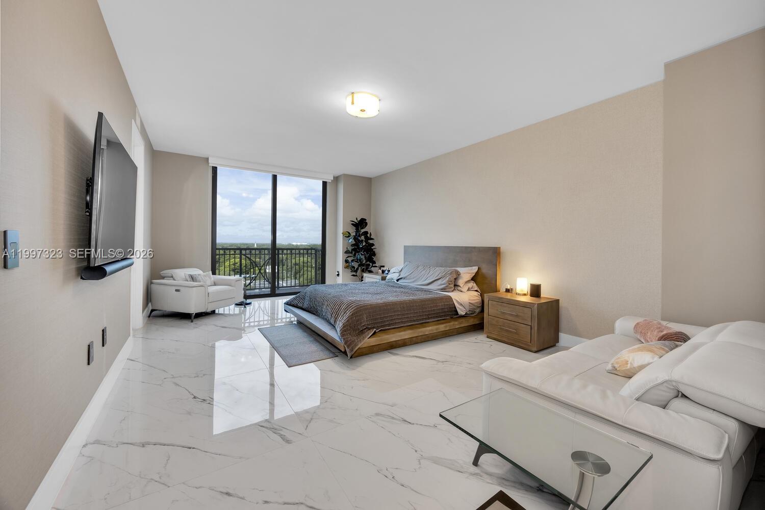 A bedroom features white marble floors, a platform bed, a sofa, and a balcony view — 301 Altara Ave, Coral Gables FL 33146, CORAL GABLES, FL