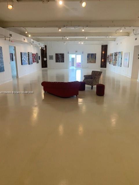 A bright room features a red tufted sofa, abstract art, and large windows overlooking buildings — 5600 NW 7th Ave, Miami FL 33127, MIAMI, FL