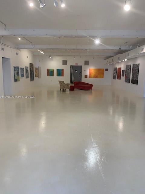 A modern, open-concept gallery space features white floors, recessed ceiling lighting, and various framed artworks — 5600 NW 7th Ave, Miami FL 33127, MIAMI, FL