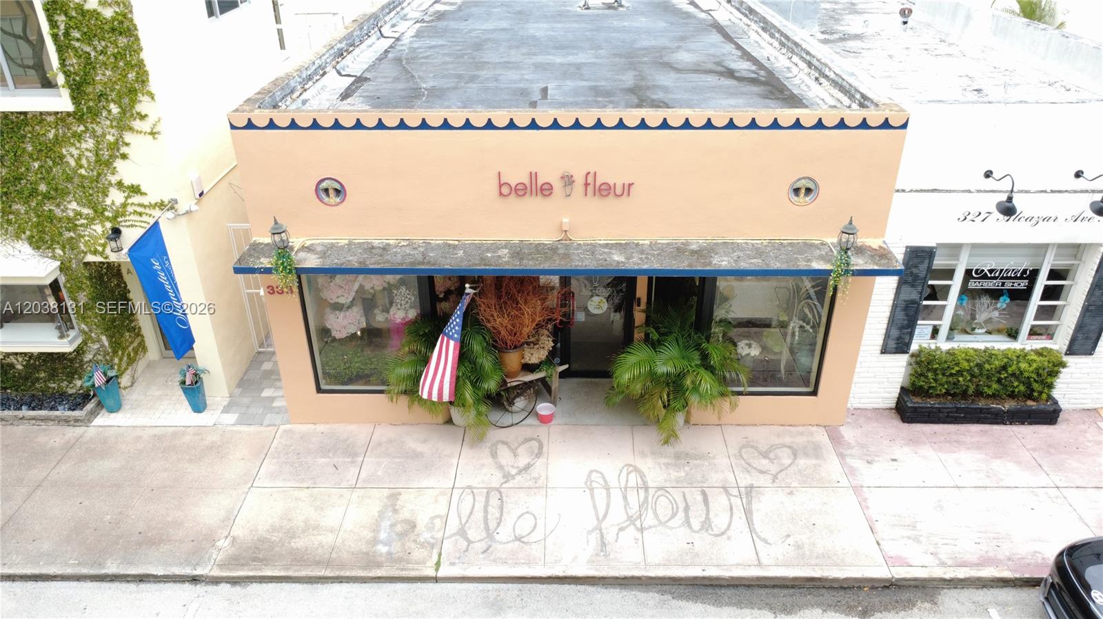 An exterior view of a peach-colored storefront with a blue awning and sidewalk signage — 333 Alcazar Ave, Coral Gables FL 33134, CORAL GABLES, FL