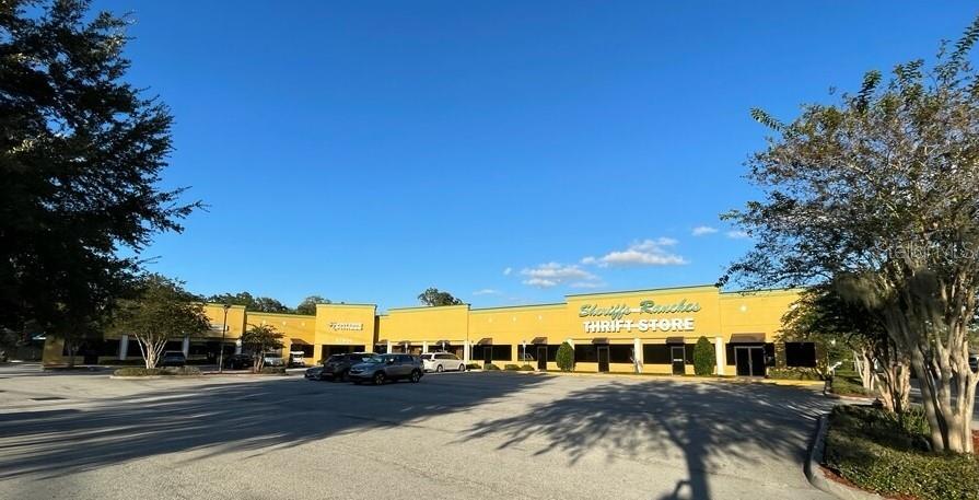 A yellow commercial strip mall with a parking lot under a clear blue sky — 27900 US HIGHWAY 27 HIGHWAY, LEESBURG, FL