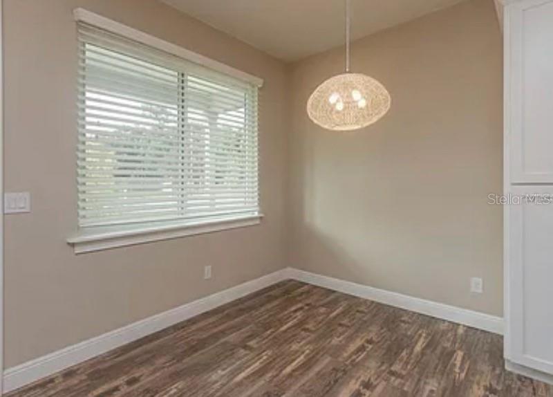 A dining area with wood-look flooring, a window with blinds, and a modern pendant light — 0 FISHER LANE WAY, OCKLAWAHA, FL