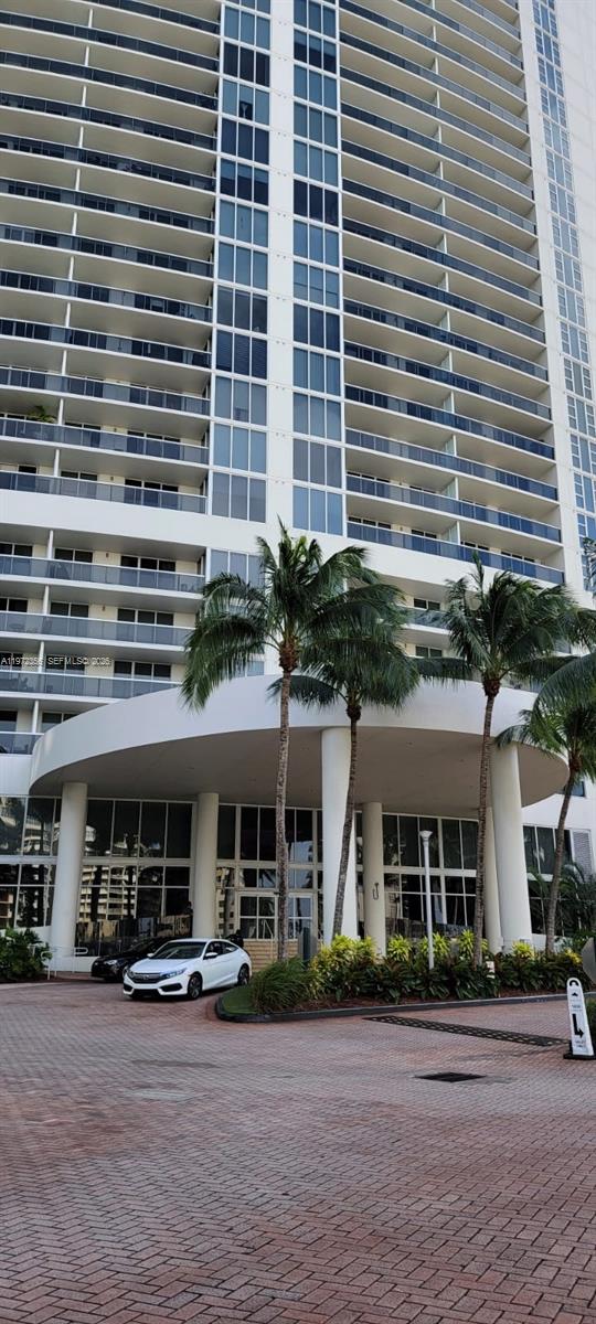 A tall residential building features a white circular porte-cochère entrance with palm trees in front — 1850 S Ocean Dr # 3007, Hallandale Beach FL 33009, HALLANDALE BEACH, FL