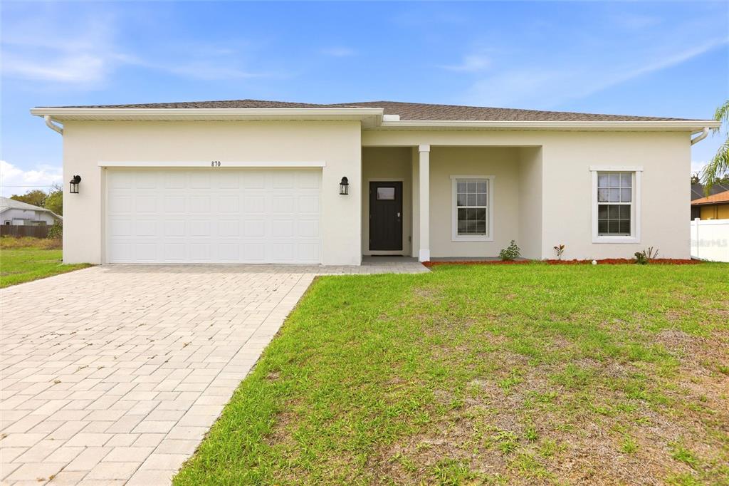 A single-story house with a white stucco exterior, a two-car garage, and a paved driveway — 870 COLUMBIA STREET, PORT CHARLOTTE, FL