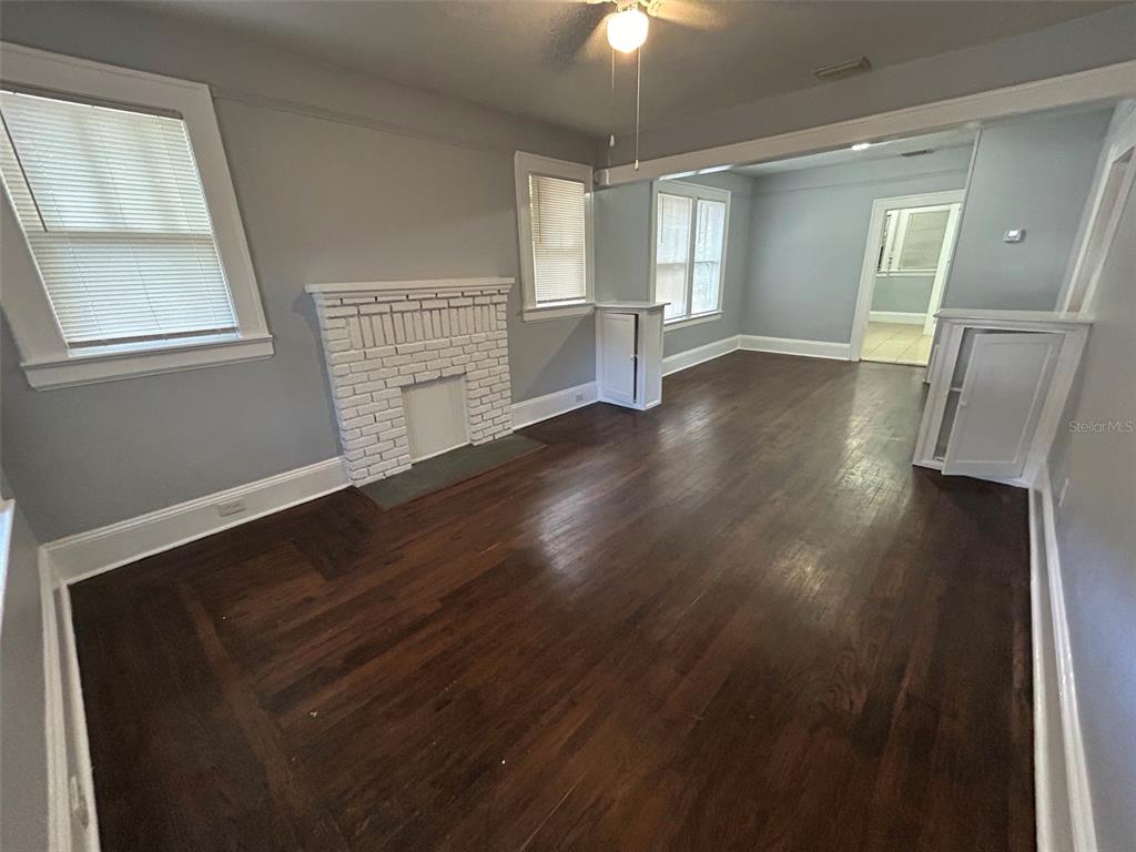 A living room features dark hardwood floors, a white brick fireplace, and light gray walls — 524 BASSWOOD STREET, JACKSONVILLE, FL