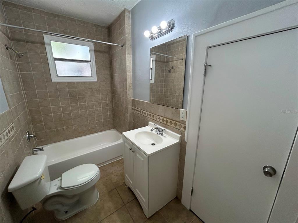 A bathroom features a white vanity, a toilet, and a tiled bathtub shower combination — 524 BASSWOOD STREET, JACKSONVILLE, FL