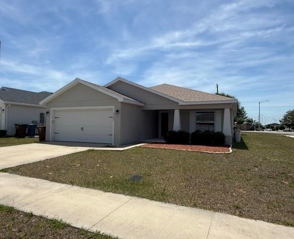 A single-story house with a beige exterior, a two-car garage, and a covered front porch — 4363 SWAN STREET, HAINES CITY, FL