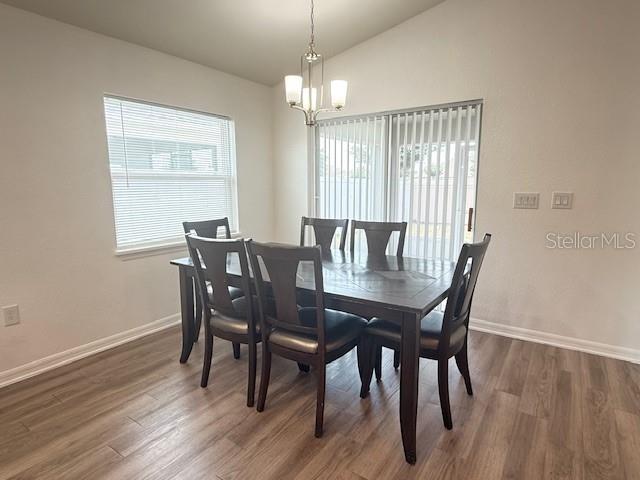 A dining room features a dark wood table with six chairs and a hanging light fixture — 4363 SWAN STREET, HAINES CITY, FL