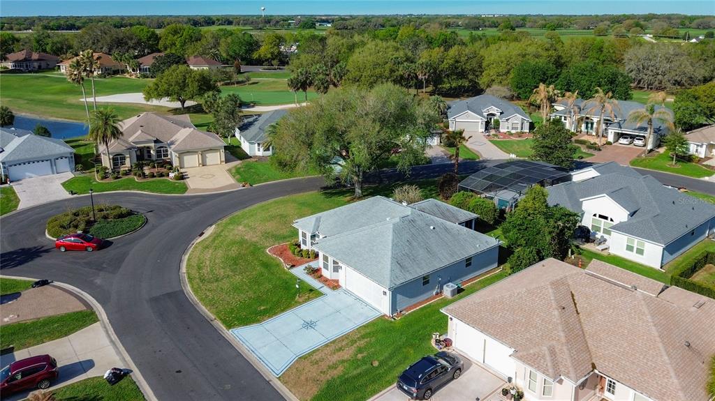 An aerial view shows several suburban houses with driveways and lawns near a golf course — 2129 ZARAGOZA PLACE, THE VILLAGES, FL