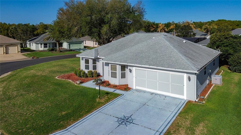 An exterior view of a light blue house with a gray roof and a paved driveway — 2129 ZARAGOZA PLACE, THE VILLAGES, FL