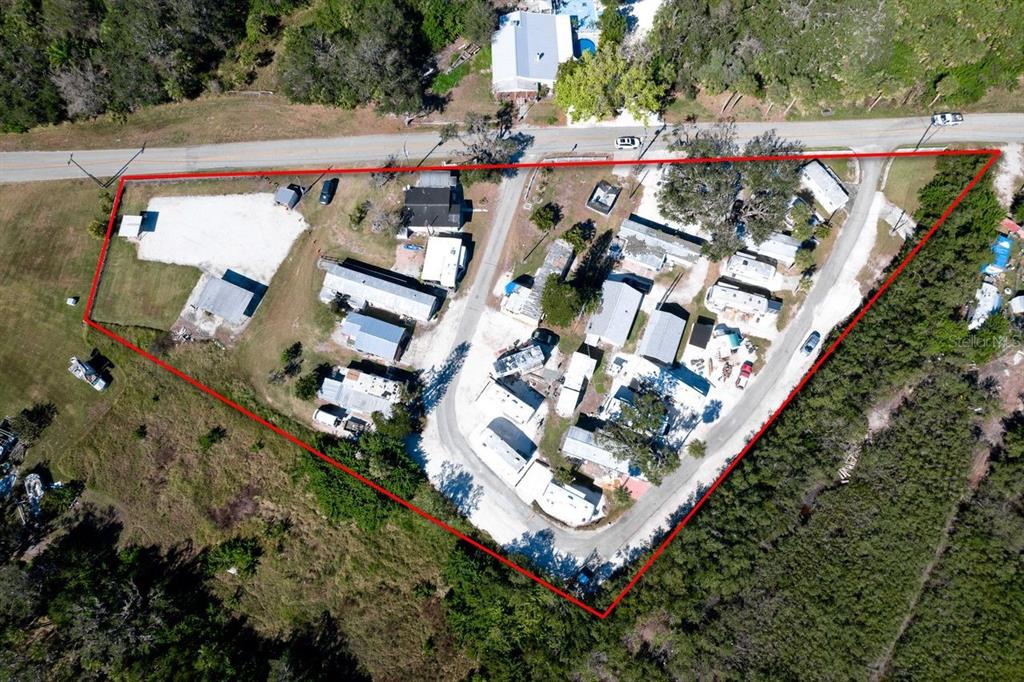 This aerial view shows a property with multiple mobile homes and structures outlined in red — 515 77TH STREET E UNIT 10, PALMETTO, FL