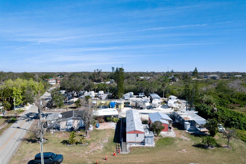 An aerial view shows a mobile home park with several trailers and a nearby road — 515 77TH STREET E UNIT 10, PALMETTO, FL