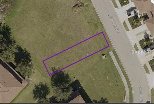 An aerial view shows a vacant rectangular lot outlined in purple along a residential street — JONAH DRIVE, NORTH PORT, FL