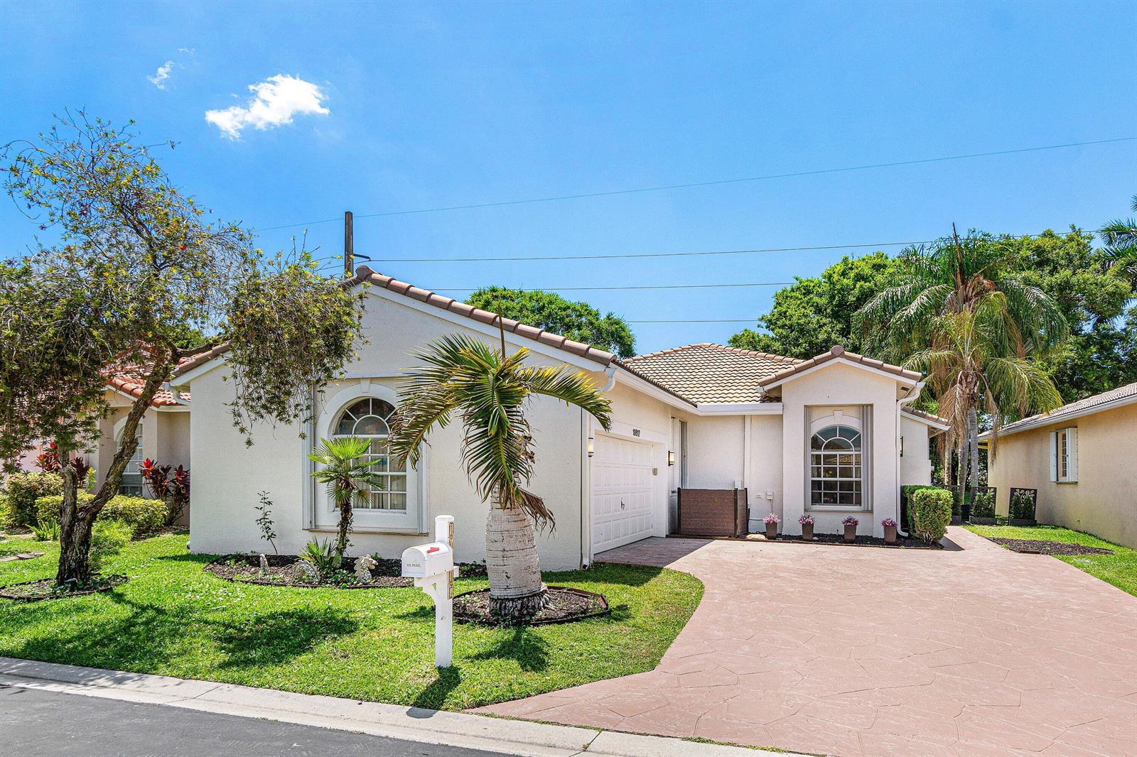 A single-story house with a white stucco exterior, a tiled roof, and a paved driveway — 10817 Fillmore Drive, Boynton Beach FL 33437, BOYNTON BEACH, FL