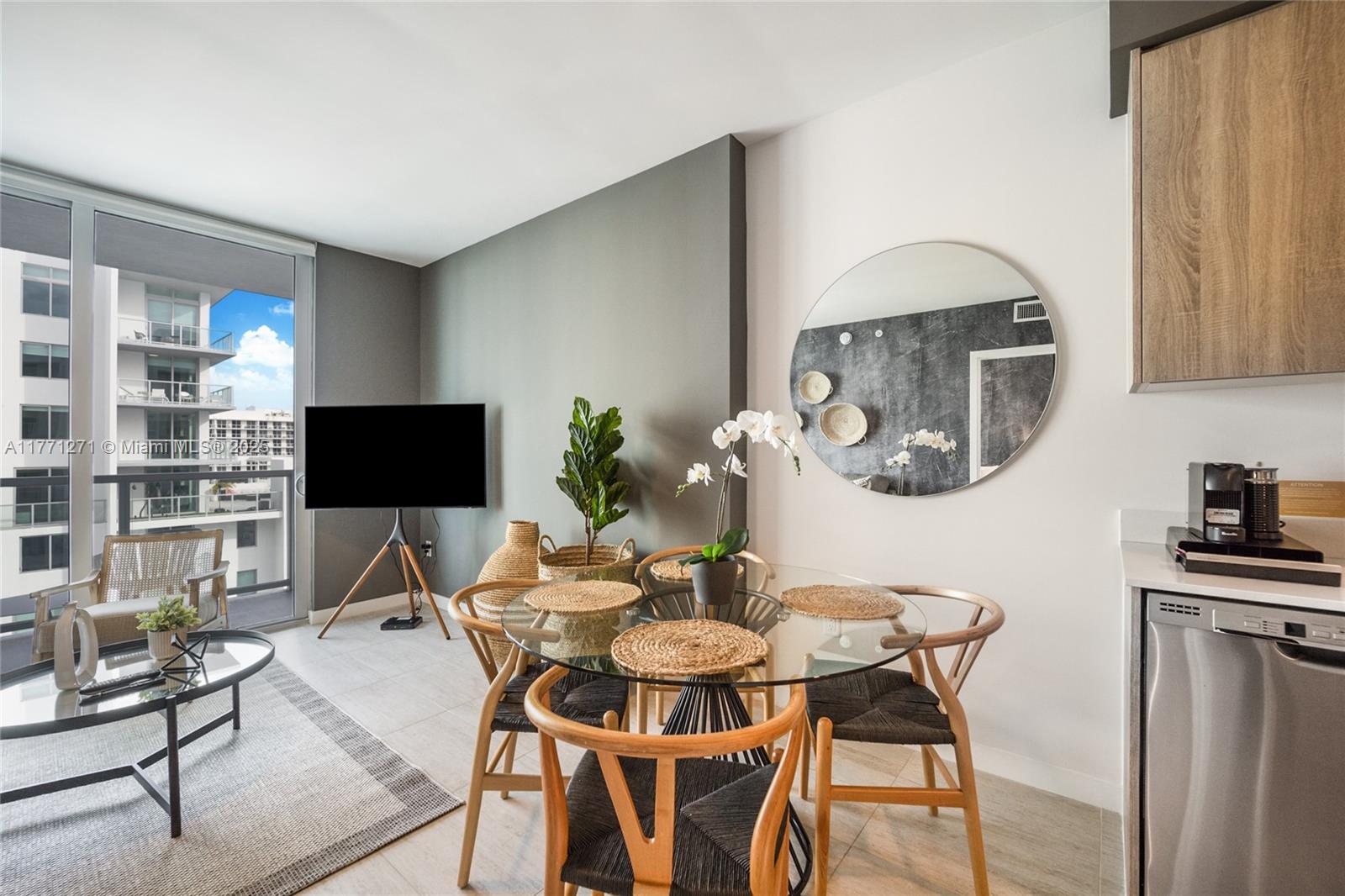 A dining area with a glass table and chairs sits next to a living space — 3900 Biscayne Blvd # 1016, Miami FL 33137, MIAMI, FL