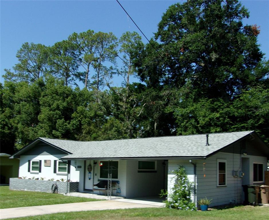 A single-story house with a gray roof, white siding, and an attached carport — 428 NE 21ST TERRACE, OCALA, FL