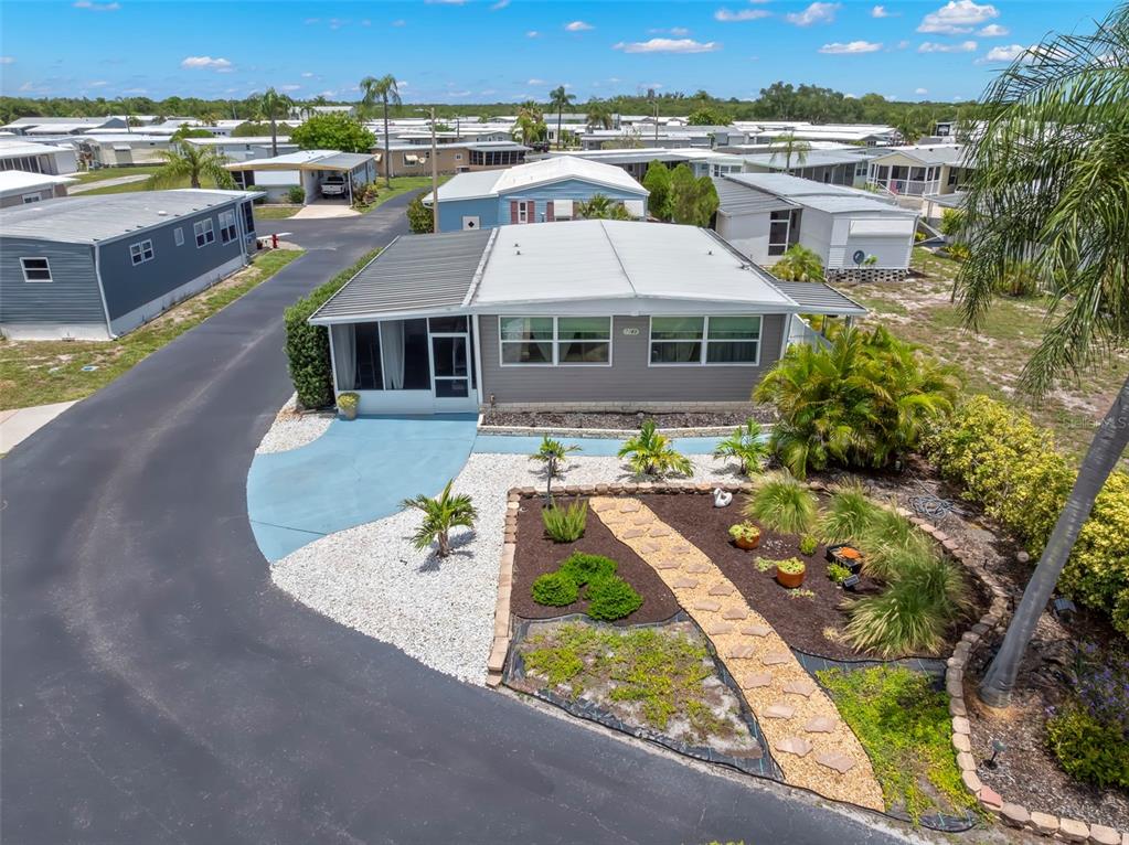 An aerial view of a manufactured home with a screened porch and landscaped front yard — 7165 MOUNT GEORGETOWN DRIVE NE UNIT 571, ST PETERSBURG, FL