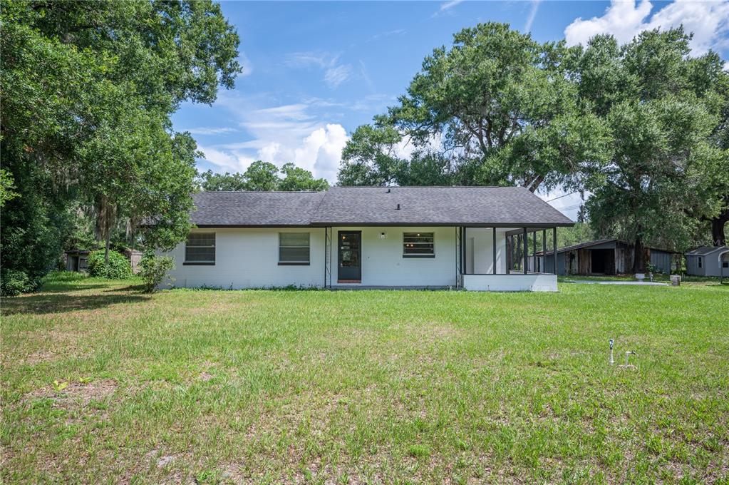 The exterior of a white, single-story house with a screened porch and a dark roof — 2008 OLD DIXIE HIGHWAY, AUBURNDALE, FL
