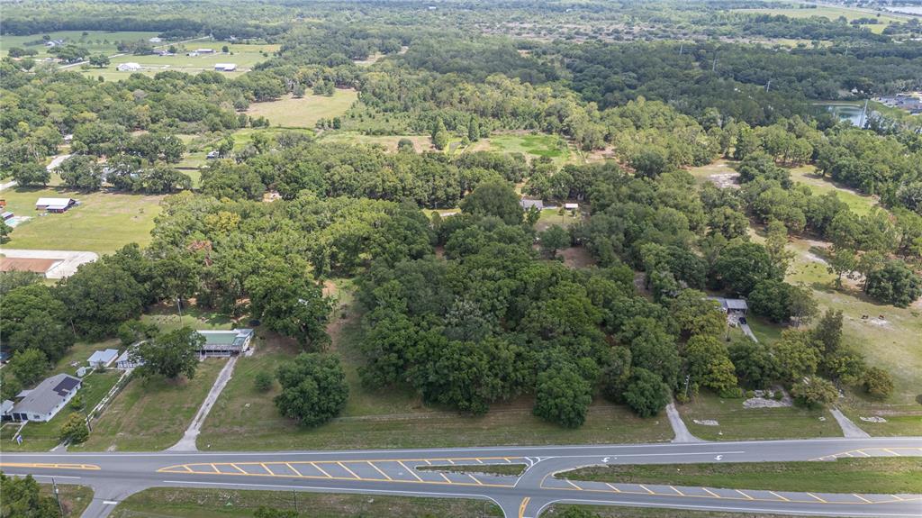An aerial view shows a wooded lot bordered by a road and nearby houses — 2008 OLD DIXIE HIGHWAY, AUBURNDALE, FL
