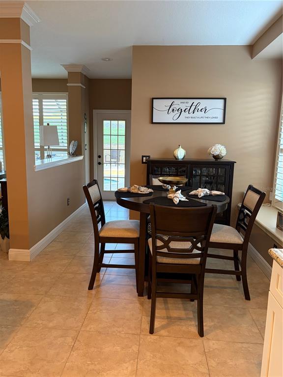 A dining area features a round wooden table with four chairs and a dark hutch — 889 EAGLE CLAW COURT, LAKE MARY, FL