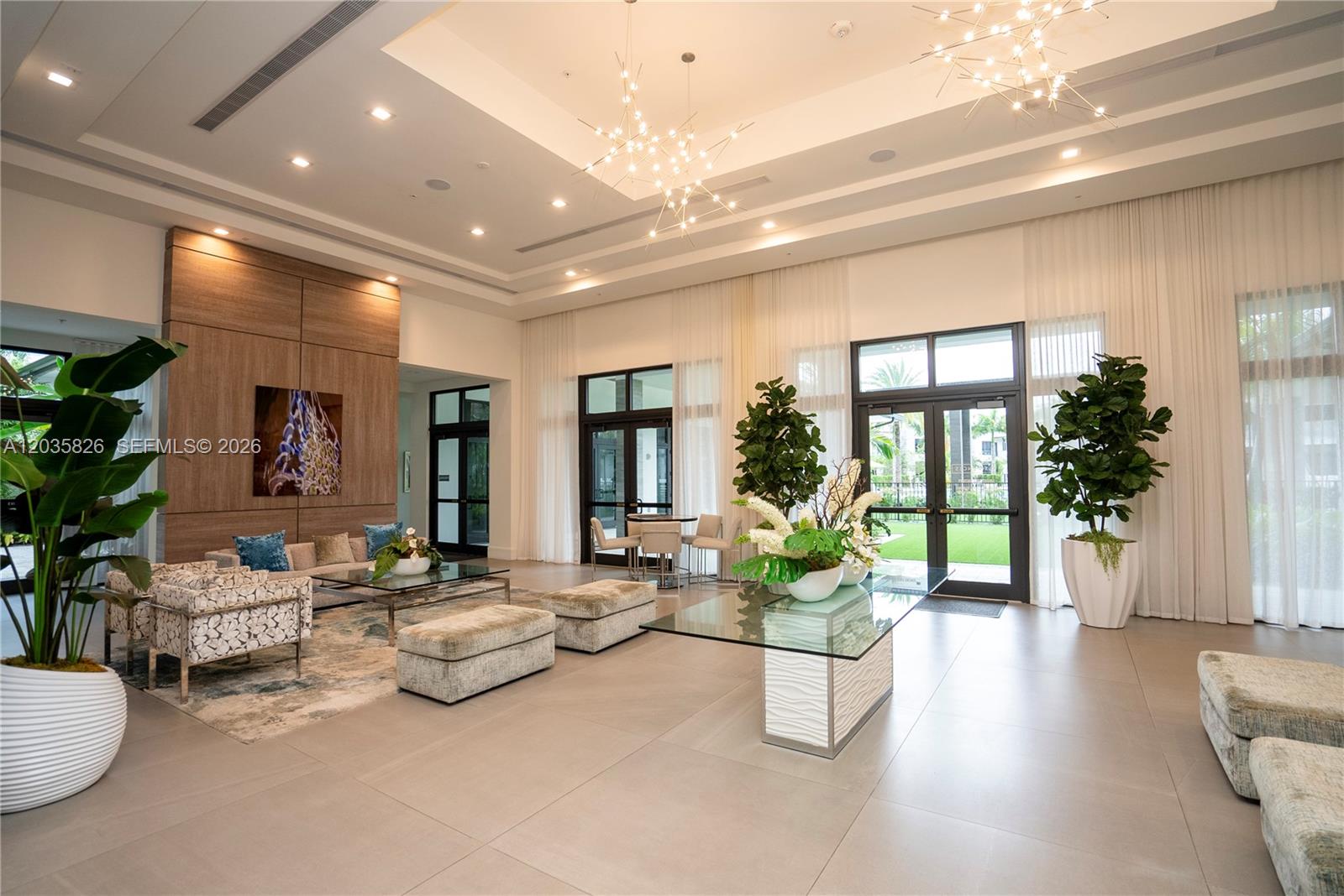 A spacious, modern lobby features high ceilings, glass chandeliers, tile flooring, and large windows — 4740 NW 84th Ct # 32, Doral FL 33166, DORAL, FL