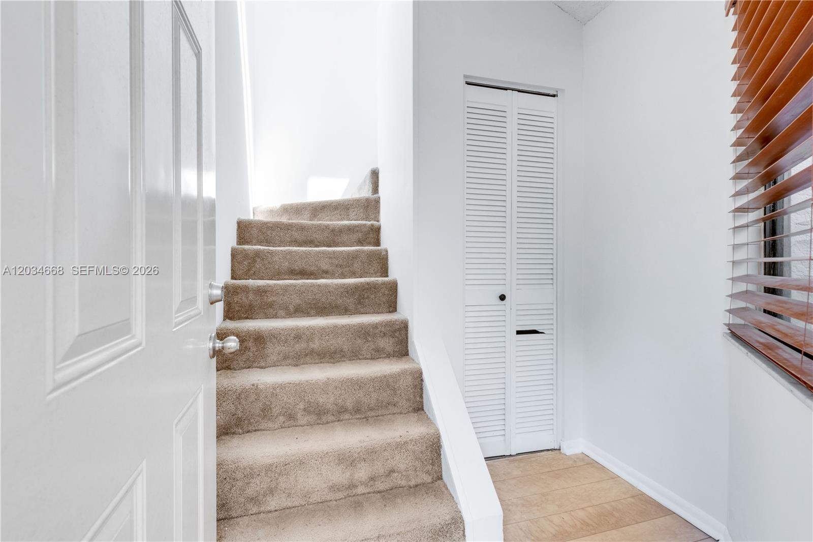A carpeted staircase leads upward next to a white louvered closet door — 104 NW 98th Ter # 104, Plantation FL 33324, PLANTATION, FL