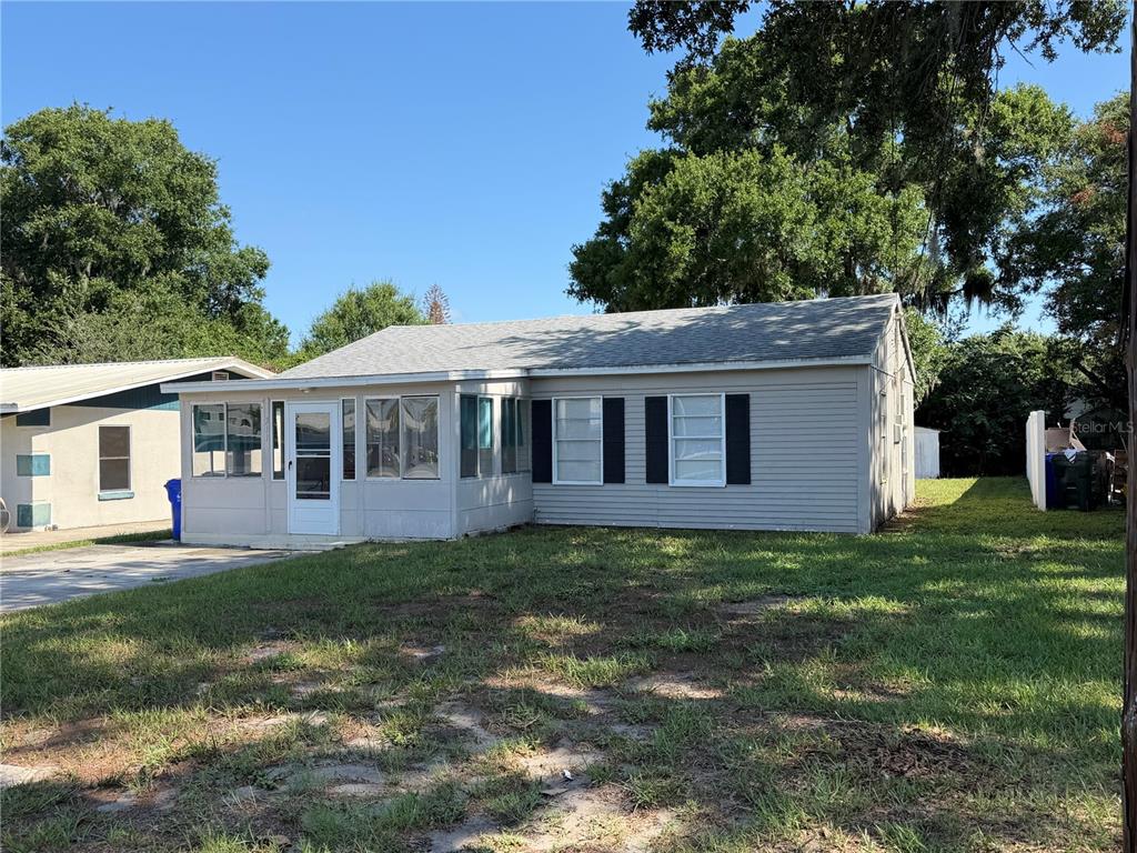 A single-story house with light gray siding, a screened-in porch, and a shingled roof — 311 W BELLA VISTA STREET, LAKELAND, FL