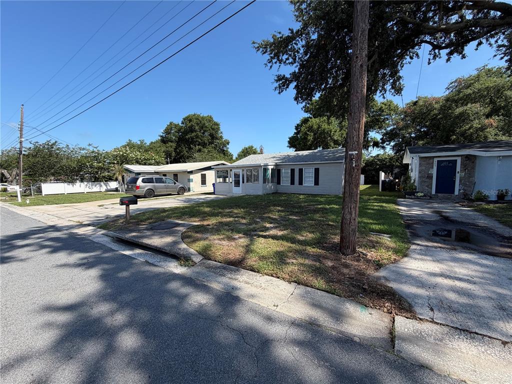 A single-story house with light gray siding and a front porch sits on a grassy lot — 311 W BELLA VISTA STREET, LAKELAND, FL