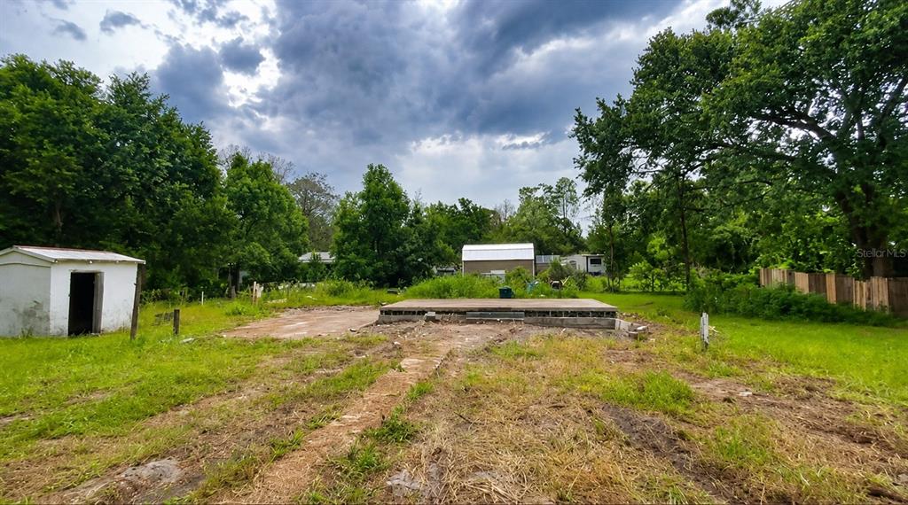 An outdoor view of a concrete foundation and a small shed on a grassy lot — 27729 LUELLA AVENUE, PAISLEY, FL