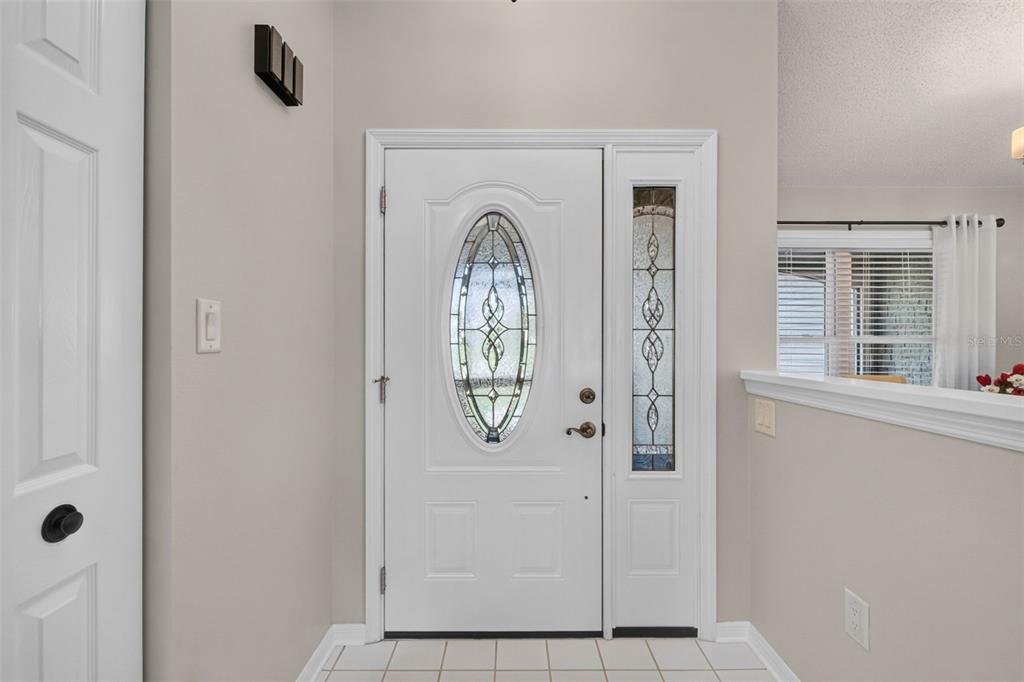 An entryway features a white front door with an oval glass insert and a sidelight — 6031 SANDERLING DRIVE, LAKELAND, FL