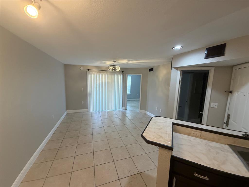 A tiled dining area features a sliding glass door and a view into another room — 1916 LAKE ATRIUMS CIRCLE UNIT 28, ORLANDO, FL