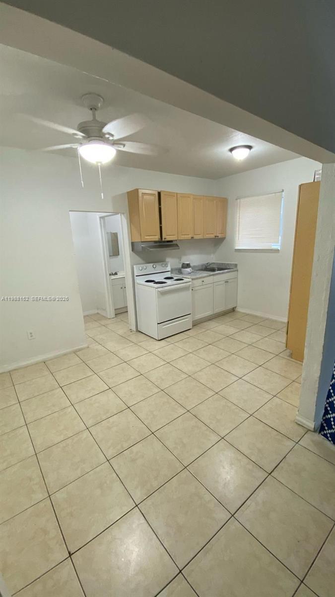 A kitchen features light-colored cabinets, white appliances, and beige tile flooring — 1021 NW 3rd st # 305, Miami FL 33128, MIAMI, FL