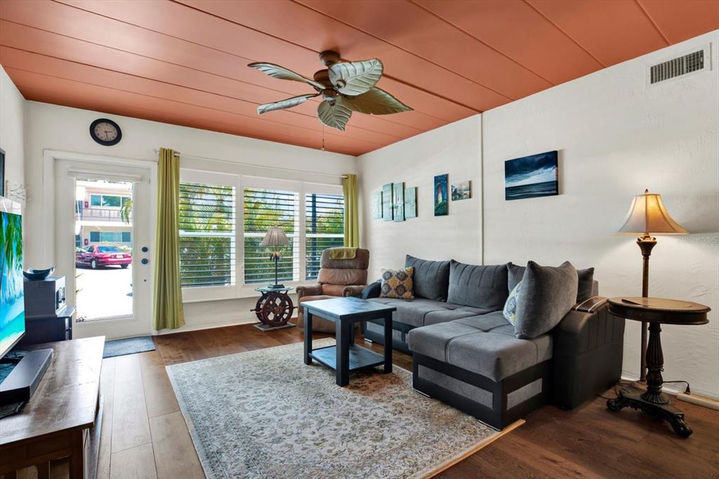 A living room features a gray sectional sofa, a ceiling fan, and a terracotta-colored ceiling — 4032 57TH STREET N UNIT 166, KENNETH CITY, FL