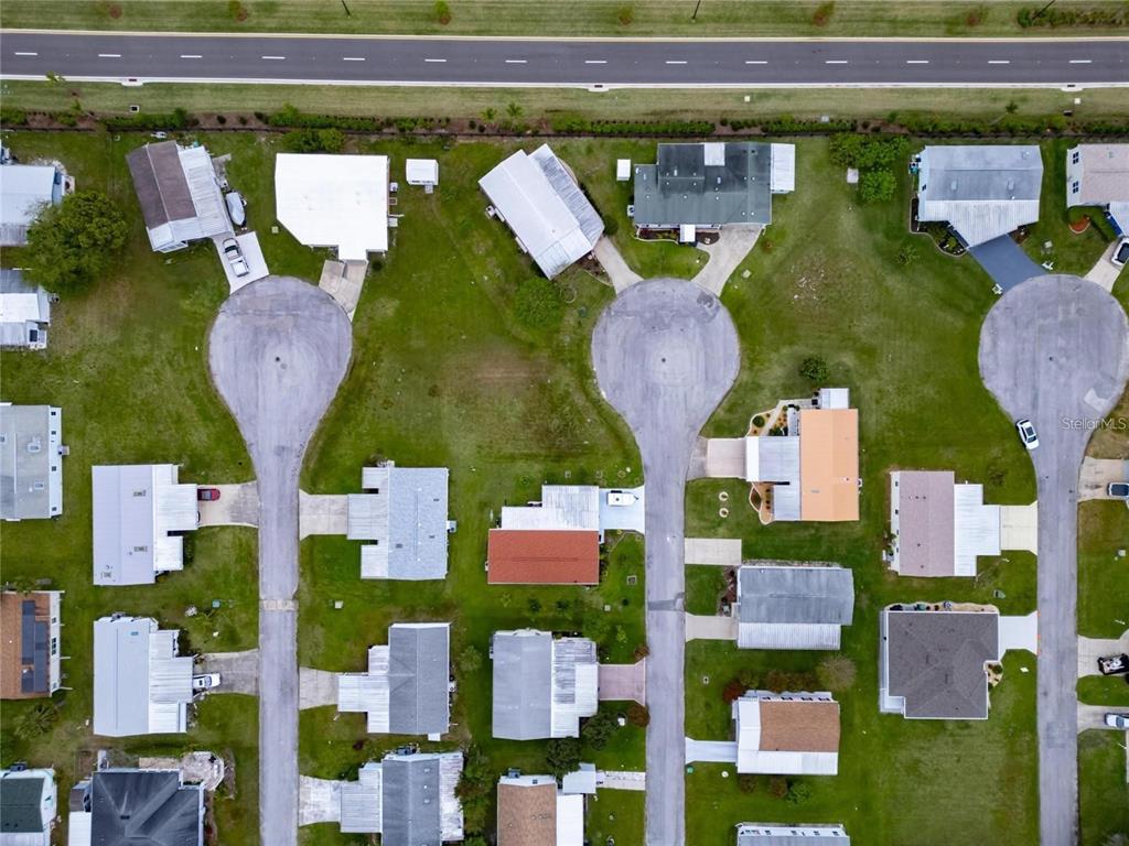 An aerial view shows several suburban houses arranged around three cul-de-sacs near a main road — LOT 30 BLK C OXFORD COURT, WILDWOOD, FL