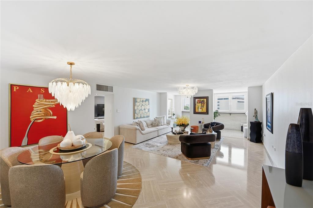 A bright, open-concept living and dining area features white walls, marble floors, and modern furniture — 100 JUAN A. CORRETJER UNIT PH-705, OLD SAN JUAN, PR