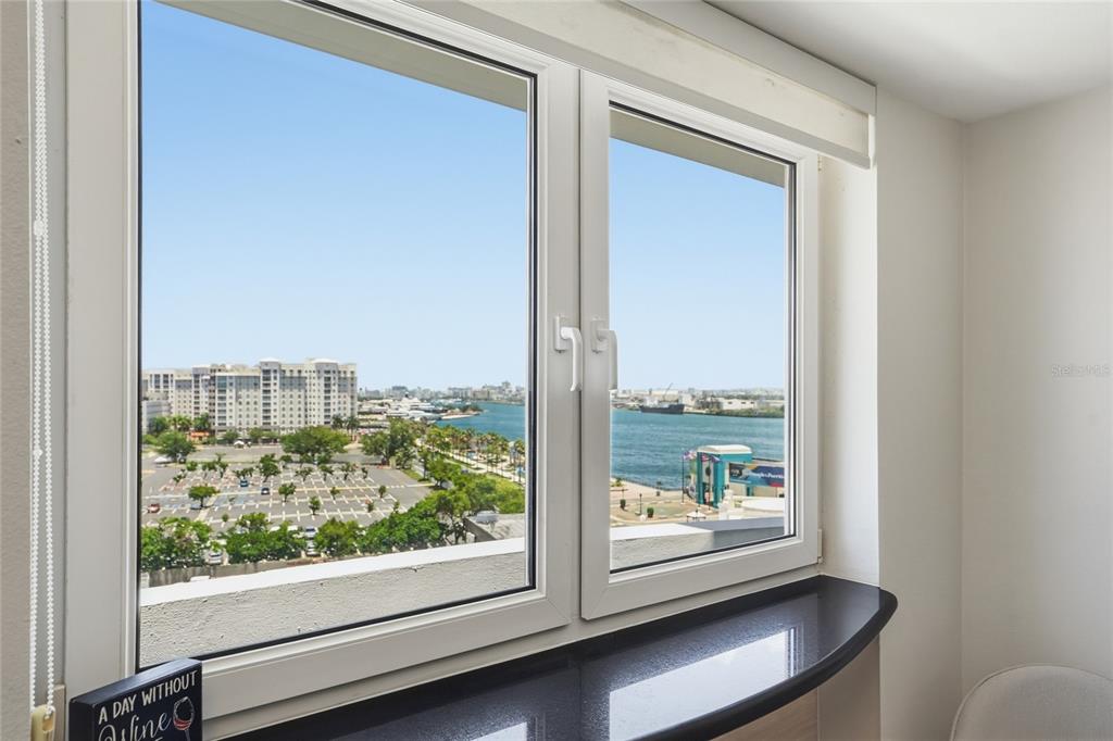 A window with a black sill overlooks a parking lot and a body of water — 100 JUAN A. CORRETJER UNIT PH-705, OLD SAN JUAN, PR
