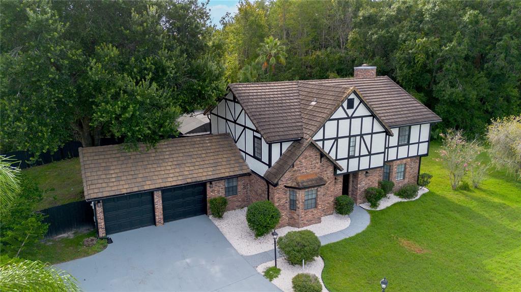 An aerial view of a two-story Tudor-style house with a brick facade and attached garage — 2540 ALBANY DRIVE, KISSIMMEE, FL