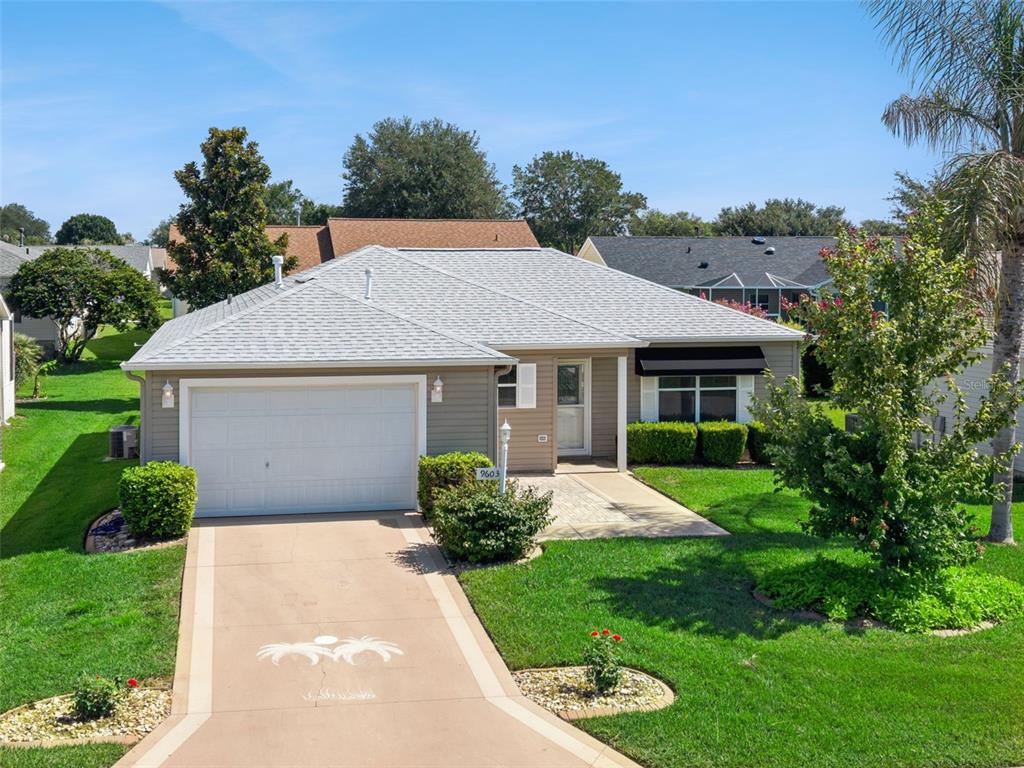 A single-story house with a light-colored garage, gray siding, and a paved driveway — 9603 SE 171ST ARGYLL STREET, THE VILLAGES, FL