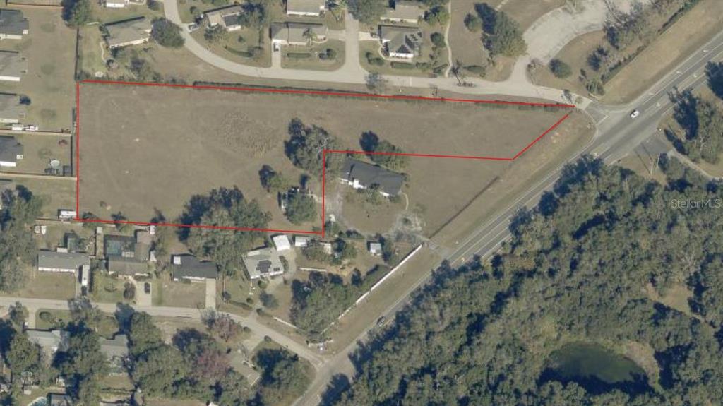 This aerial view shows a residential property lot outlined in red with a house — TWIN LAKE CIRCLE, UMATILLA, FL
