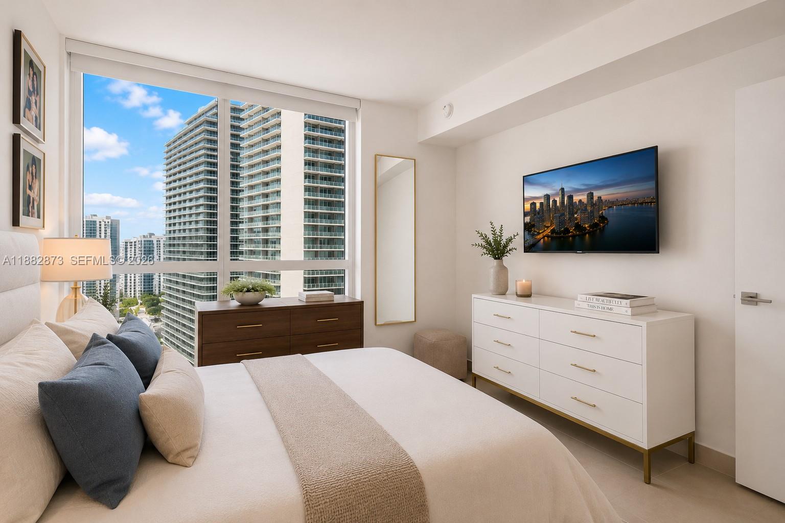 A bedroom features a bed, a white dresser with a television, and floor-to-ceiling windows — 1080 Brickell Ave # 2503, Miami FL 33131, MIAMI, FL