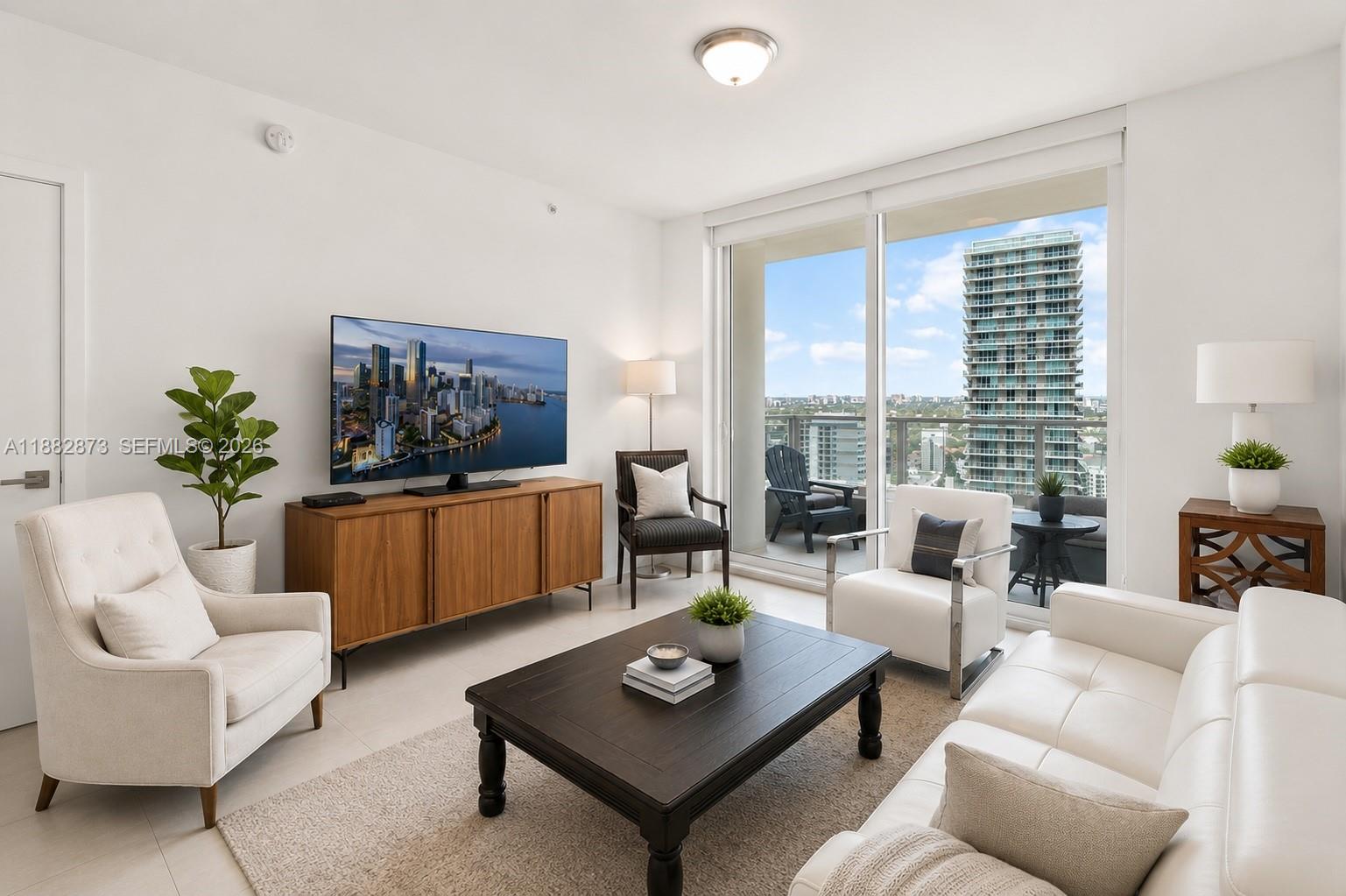A bright living room features a white sofa, armchairs, a coffee table, and a balcony view — 1080 Brickell Ave # 2503, Miami FL 33131, MIAMI, FL