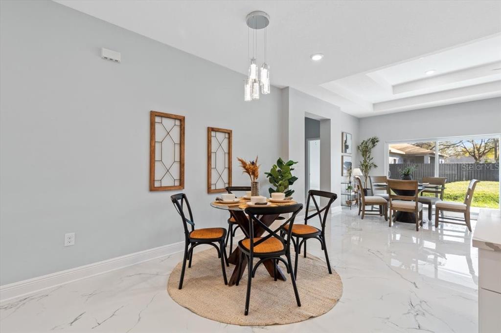 A dining area features a round table with four chairs on a circular jute rug — 6605 24TH AVENUE S, TAMPA, FL