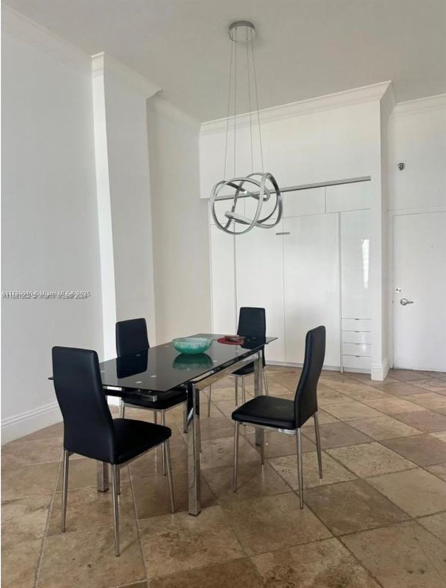 A dining area features a glass-topped table, four black chairs, and a modern metal chandelier — 6770 Indian Creek Dr, Miami Beach FL 33141, MIAMI BEACH, FL