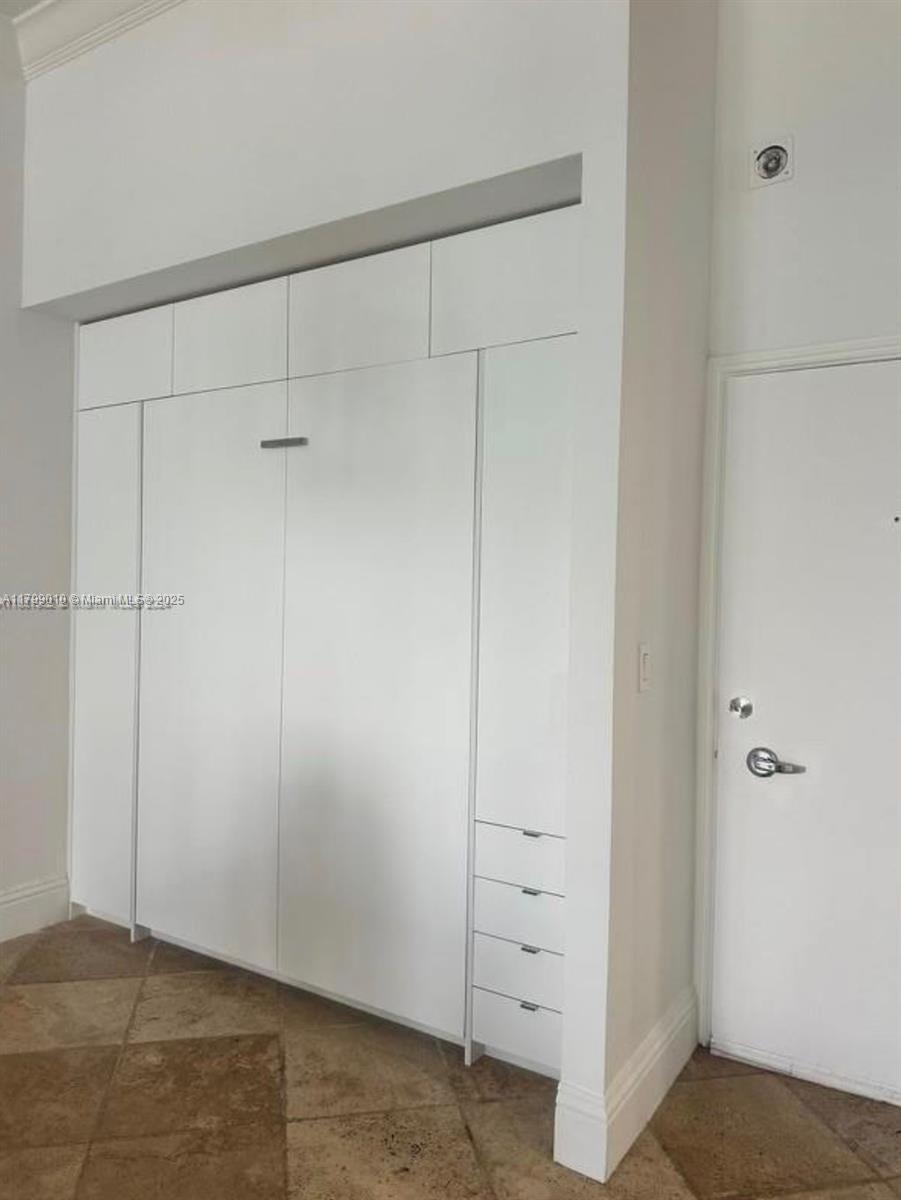A white wall unit with a Murphy bed and integrated drawers stands beside a door — 6770 Indian Creek Dr, Miami Beach FL 33141, MIAMI BEACH, FL