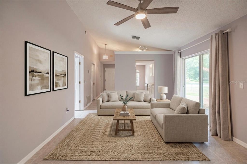 A living room features a vaulted ceiling, a ceiling fan, two sofas, and a rug — 5437 LEHIGH AVENUE, ORLANDO, FL