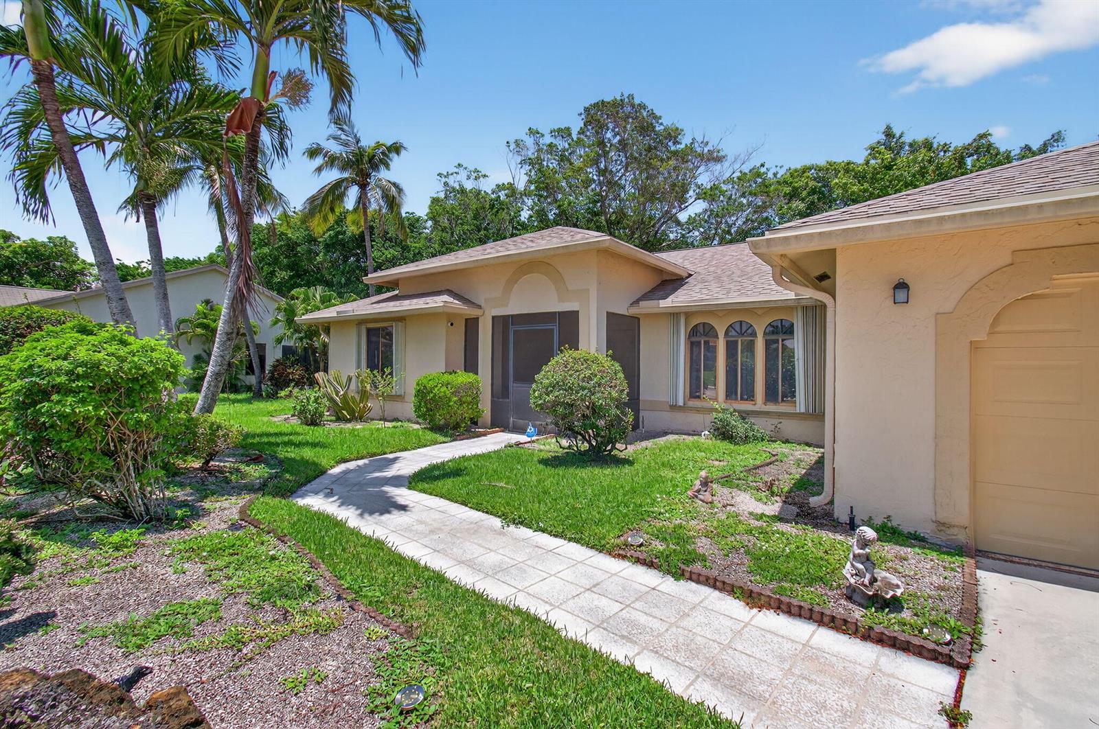 A single-story house with a beige stucco exterior, a tiled walkway, and palm trees — 2925 Riviera Drive, Delray Beach FL 33445, DELRAY BEACH, FL