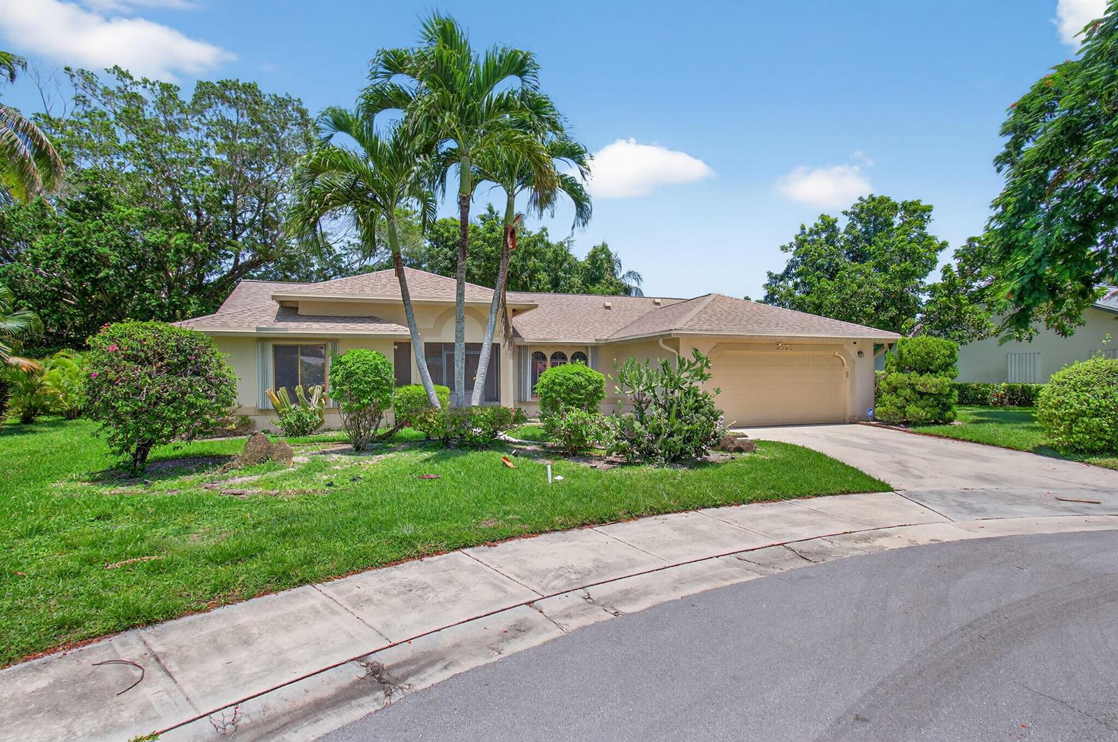 A single-story house with a tan exterior, a two-car garage, and palm trees in front — 2925 Riviera Drive, Delray Beach FL 33445, DELRAY BEACH, FL